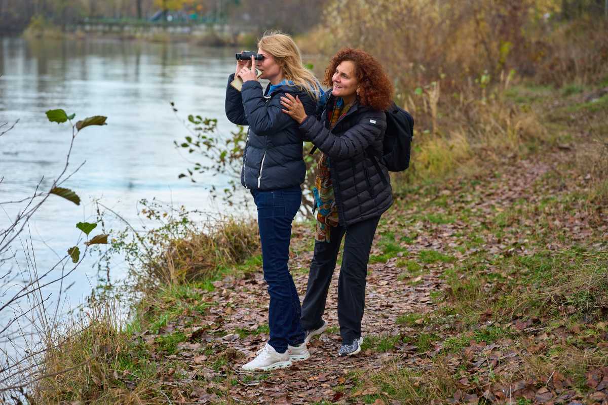 Famiglia con bambini su passerella in legno nell'Oasi di Vallevecchia, natura verde, cartelli didattici, Caorle sullo sfondo, giornata soleggiata